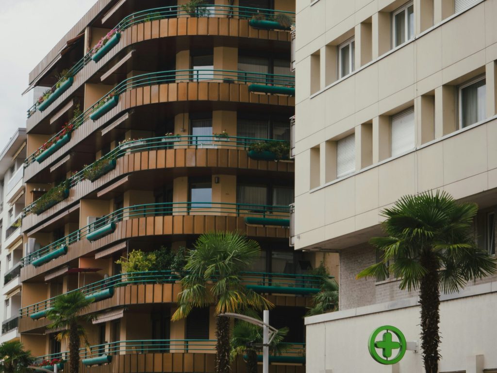 Modern apartment buildings with balconies and palm trees.