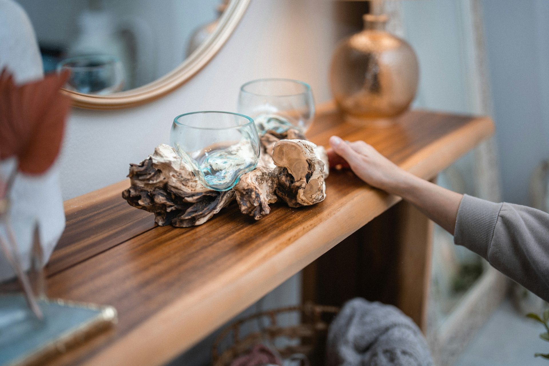a person reaching for a glass on a table